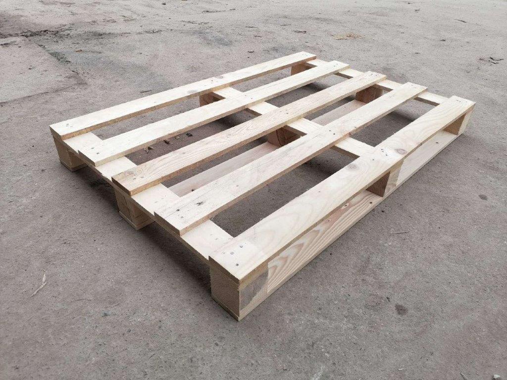 Fotorealistična slika drvene palete na sivom betonskom podu.